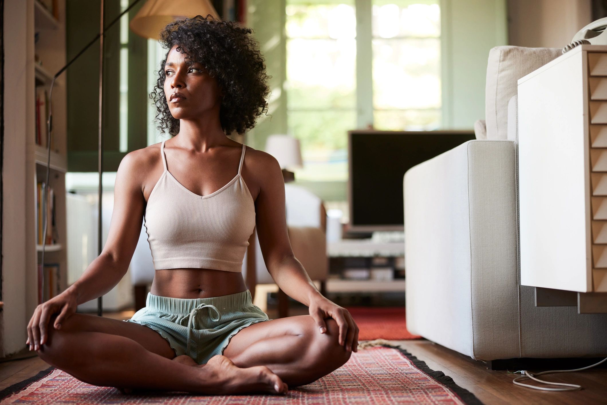Portrait of a woman sitting in a relaxed yoga posture at home