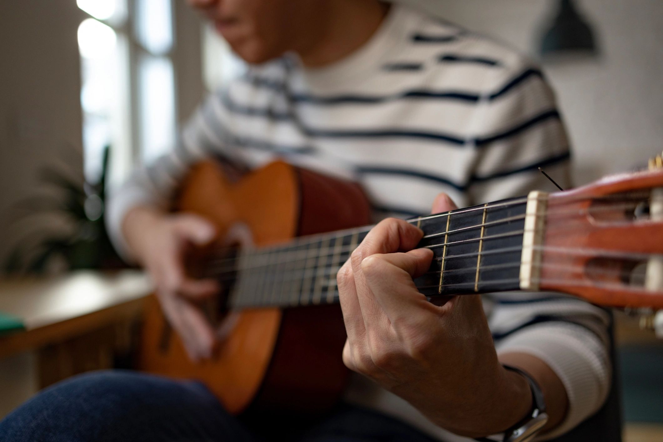 Close up of hands playing an acoustic guitar